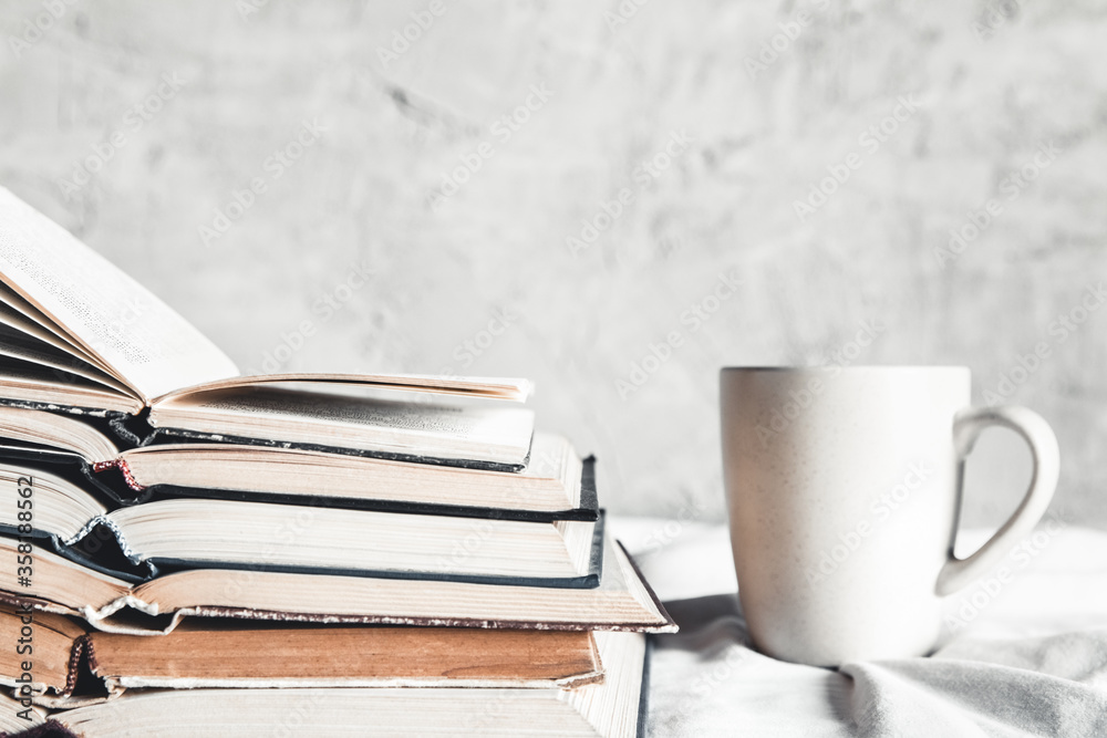 Stack of opened books with a cup of coffee in bed Stack of opened books with a cup of coffee in bed