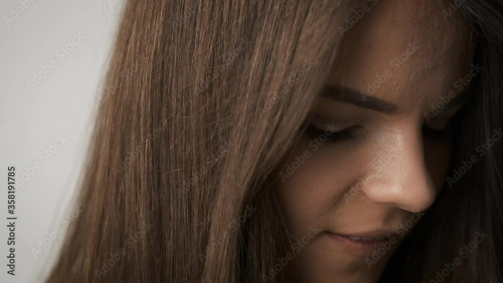 Beautiful woman stands in front of a mirror and admires herself. Hair care Beautiful woman stands in front of a mirror and admires herself. Hair care