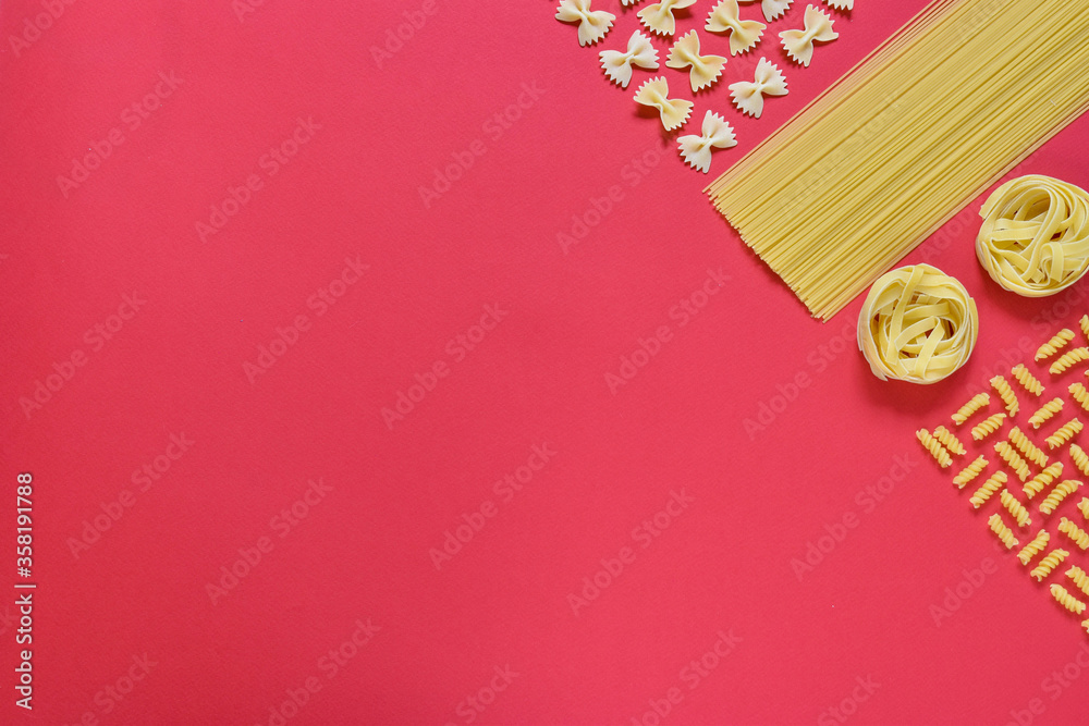Different types of pasta on a red background.