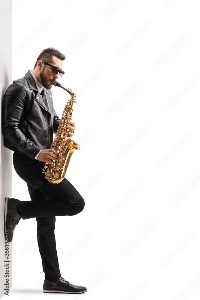 Naklejka premium Sax player leaning on a wall and playing