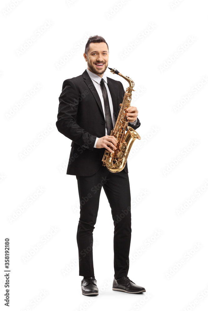 Naklejka premium Man in a suit standing and holding a saxophone