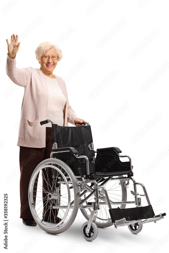Elderly woman pushing an empty wheelchair and waving at camera Elderly woman pushing an empty wheelchair and waving at camera