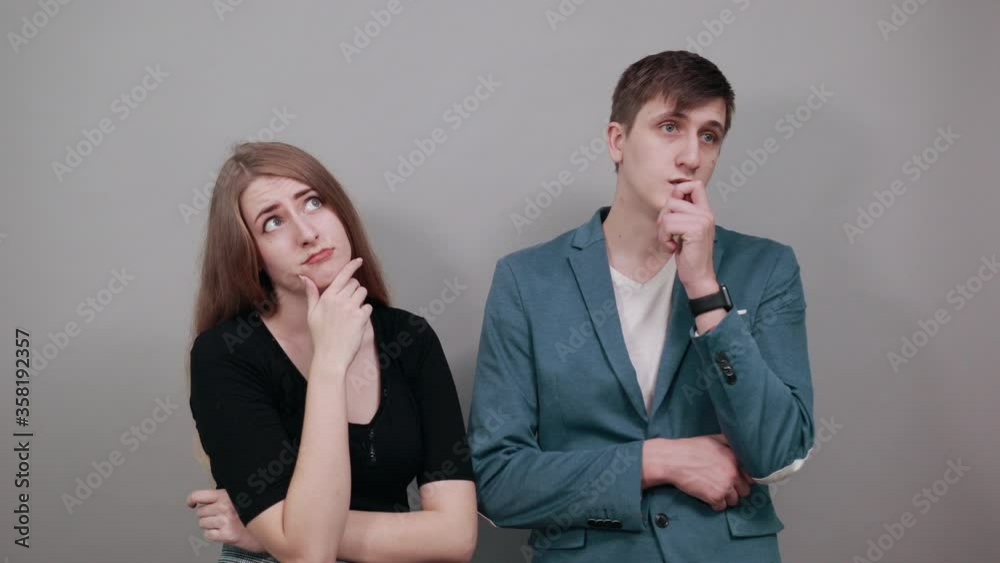 Hand on chin thinking about question, pensive expression. Doubt. Thoughtful face. Using that incredibly sharp business mind. Young attractive couple boyfriend girlfriend two people, dressed t-shirt Hand on chin thinking about question, pensive expression. Doubt. Thoughtful face. Using that incredibly sharp business mind. Young attractive couple boyfriend girlfriend two people, dressed t-shirt