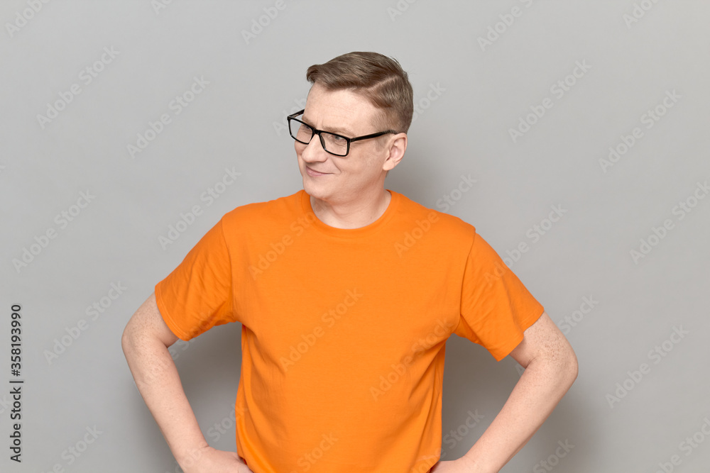 Portrait of happy mature man with glasses, wearing orange T-shirt Portrait of happy mature man with glasses, wearing orange T-shirt