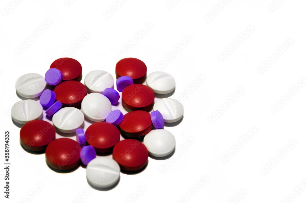 Medications, tablets of three colors (white, red and purple) lie on a white surface and laid out in the shape of a heart. Do not be sick - be healthy Medications, tablets of three colors (white, red and purple) lie on a white surface and laid out in the shape of a heart. Do not be sick - be healthy