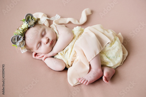 
beautiful newborn girl in a beautiful lace dress sleeps on a pink background

