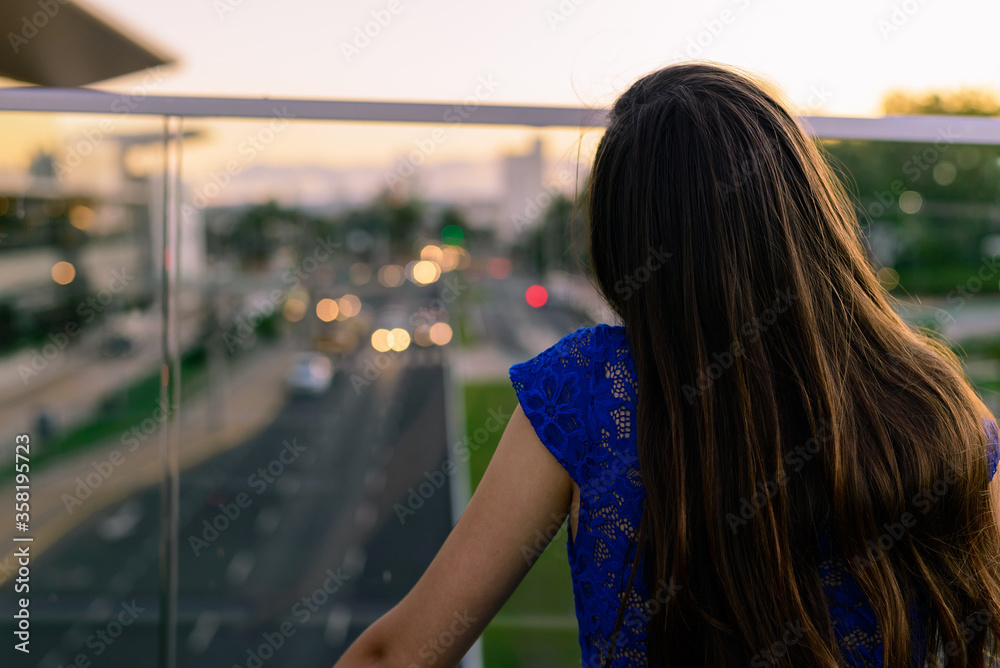 Girl watching cars pass under the bridge