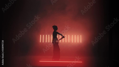 Flamenco Silhouette. Dancer in the dark room. Llight from behind. Smoke background. Slow motion