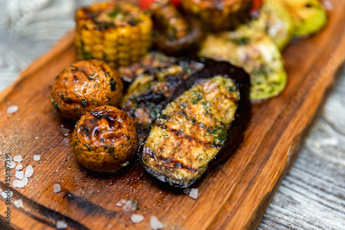 Various tasty grilled vegetables and mushrooms on rustic background