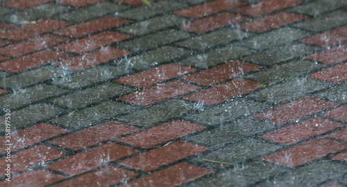 Wet granite stone tiles on a city street during the rain