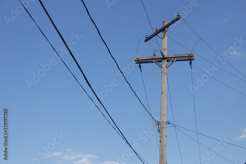 high voltage power lines against blue sky