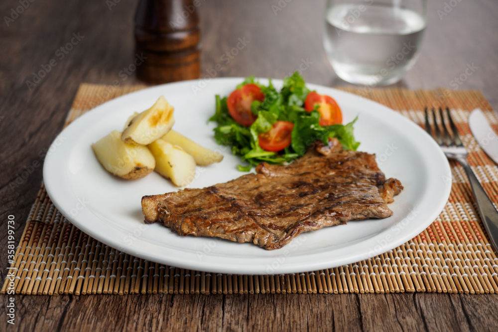Narrow beef steak with potatoes and rocket salad and cherry tomatoes Narrow beef steak with potatoes and rocket salad and cherry tomatoes