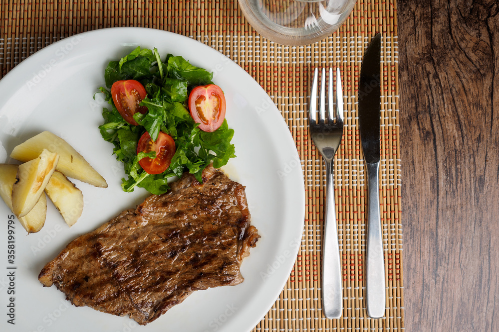 Narrow beef steak with potatoes and rocket salad and cherry tomatoes Narrow beef steak with potatoes and rocket salad and cherry tomatoes