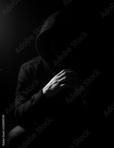 Low key photography, crossed hands of a raper 