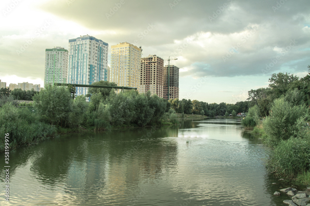 Building a house near the water in the park. Cityscapes with beautiful forest and trees. Stock photo background.