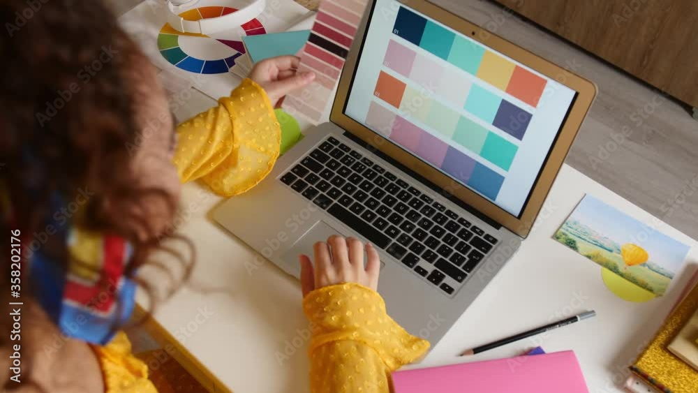 African-American designer working on laptop at home