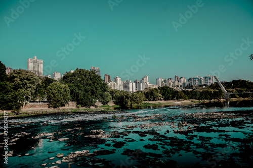 piracicaba river with city in the background and blue sky © Ronnie Souza