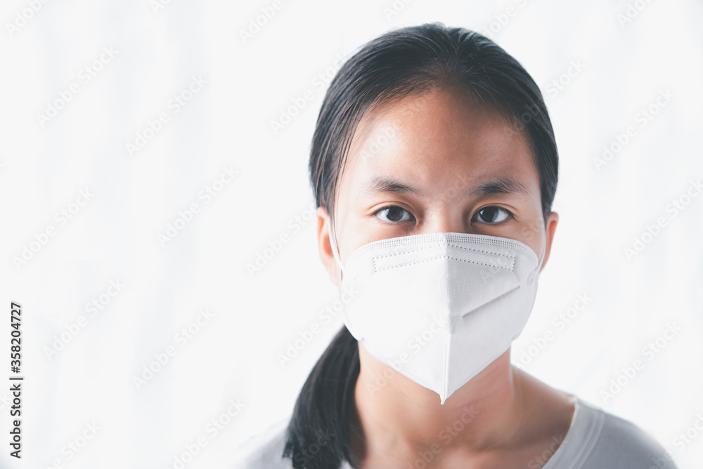 The girl close up in the white background Put on a mask to help prevent the spread of coronavirus. Put mask to fight against Corona virus or COVID-19 The girl close up in the white background Put on a mask to help prevent the spread of coronavirus. Put mask to fight against Corona virus or COVID-19