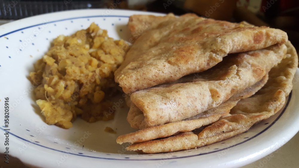 Trinidad and Tobago's folded flour Roti with potato and chickpeas curried sauce. Trinidad and Tobago's folded flour Roti with potato and chickpeas curried sauce.