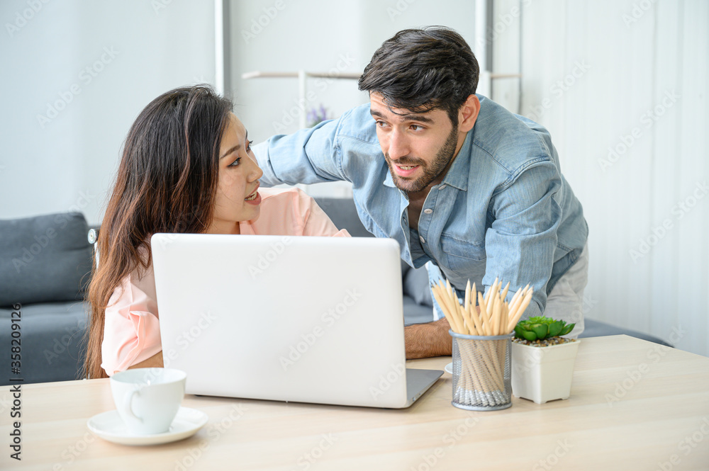 Happy and relax lifestyle of young couple lover wearing casual dress together working on laptop notebook computer in living room at home. Happy and relax lifestyle of young couple lover wearing casual dress together working on laptop notebook computer in living room at home.