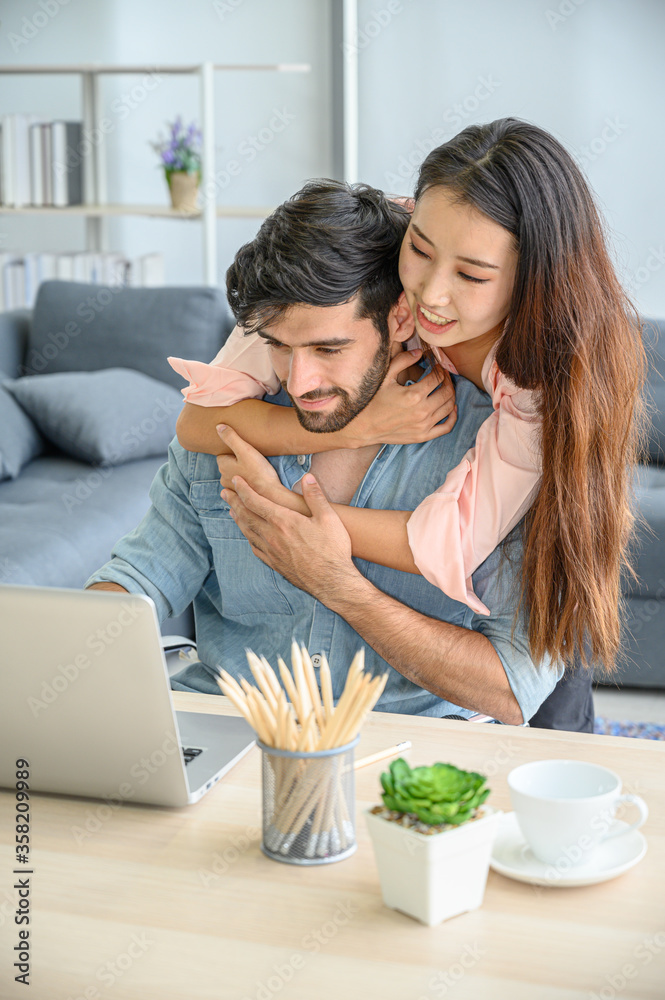 Happy and relax lifestyle of young couple lover wearing casual dress together working on laptop notebook computer in living room at home. Happy and relax lifestyle of young couple lover wearing casual dress together working on laptop notebook computer in living room at home.
