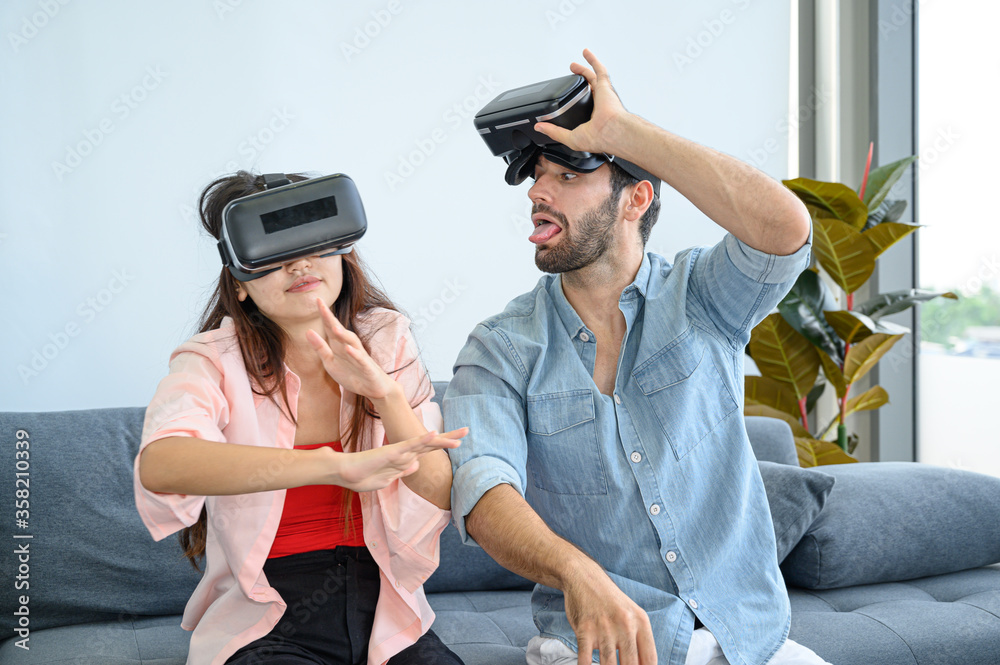 Couple lovers enjoy  playing VR game together at home.
