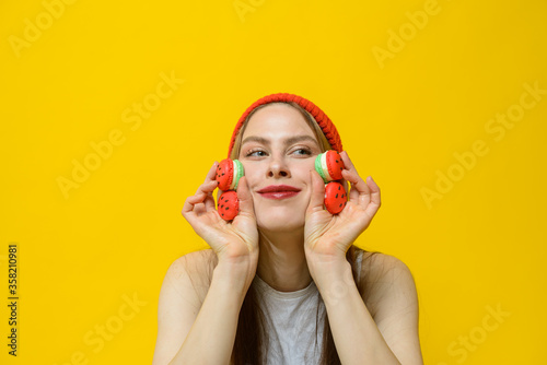 young woman in a red hat with macarons in hands