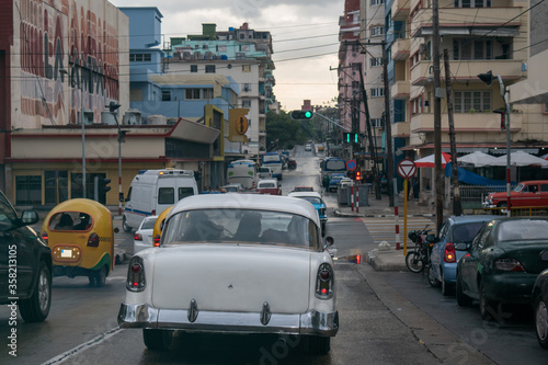 Nostalgic retro and modern imported cars clash in downtown Havana, Cuba.