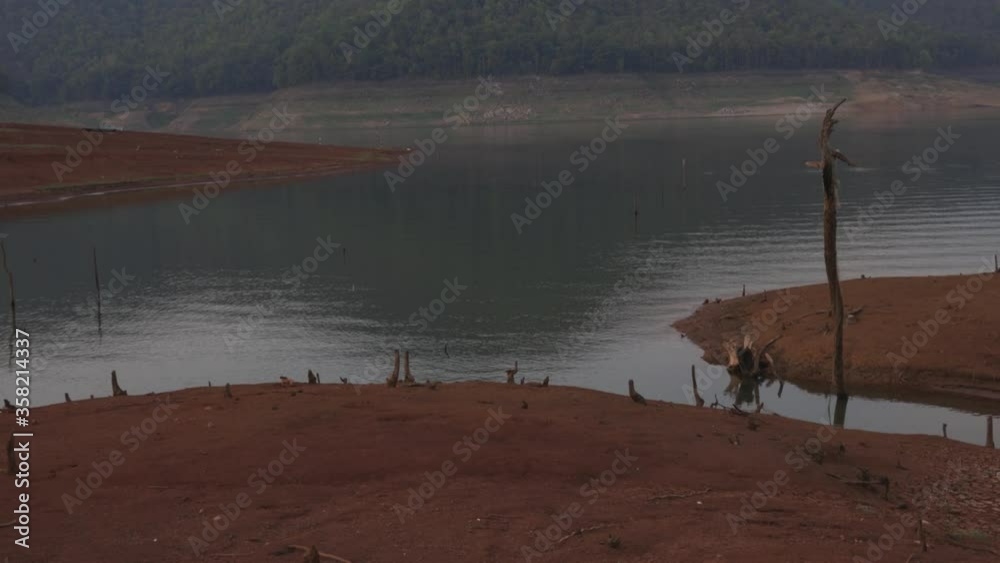 Tilting down shot of mountain range and a lake with small isles and an old abandoned white fishing net on the water edge. Tilting down shot of mountain range and a lake with small isles and an old abandoned white fishing net on the water edge.