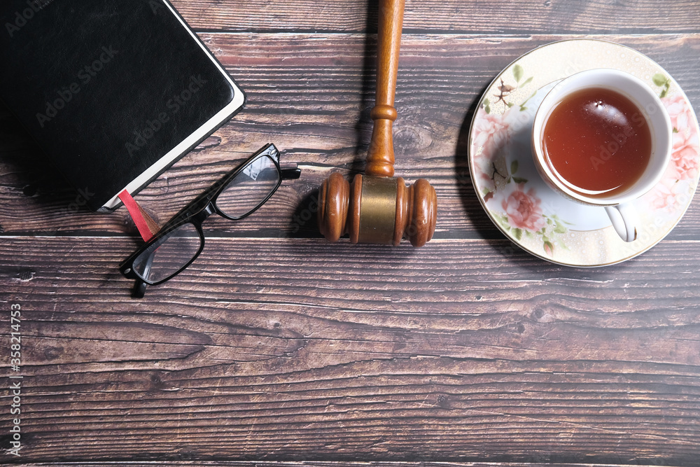 Top view of gavel, book and tea on table 