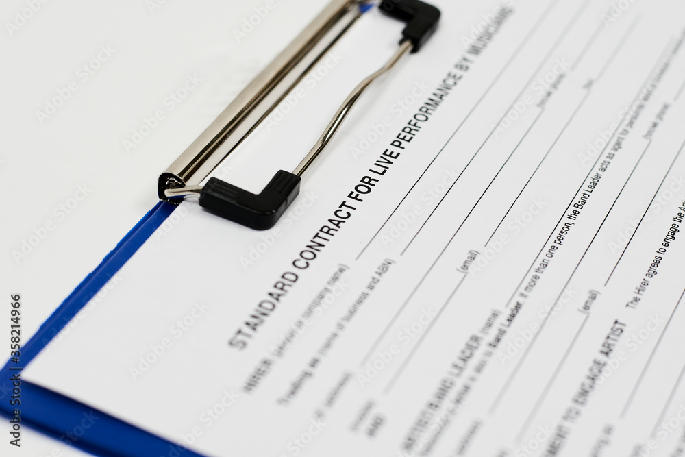 Signing standart contract for live performance by musicians. A musician filling live performance contract Signing standart contract for live performance by musicians. A musician filling live performance contract