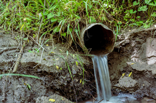Fotografía Water flowing from the open outlet of a metal agriculture drainage tile