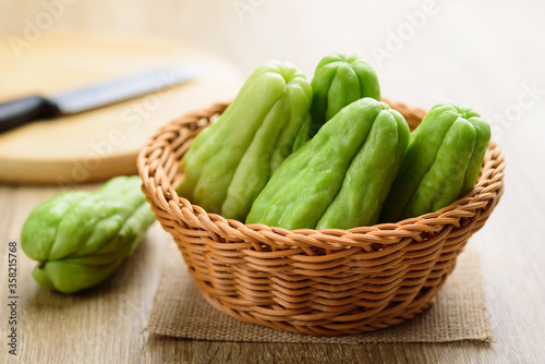 Chayote squash or Mirlition squash in a basket on wooden background, Organic vegetable, Edible plant fruit	
 photo