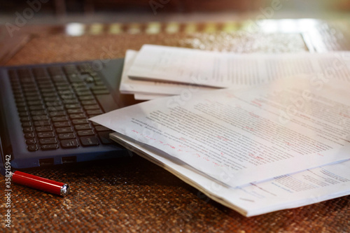 blurred paperwork over laptop on table in office