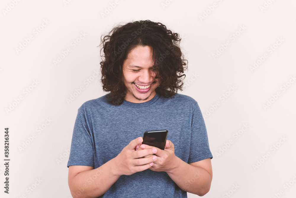 Portrait of Asian man smiling and holding mobile phone
