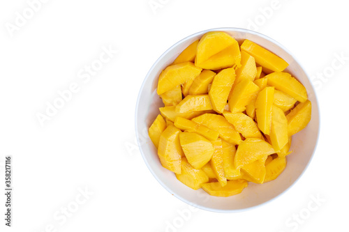 Beautiful yellow ripe mangoes in a bowl.