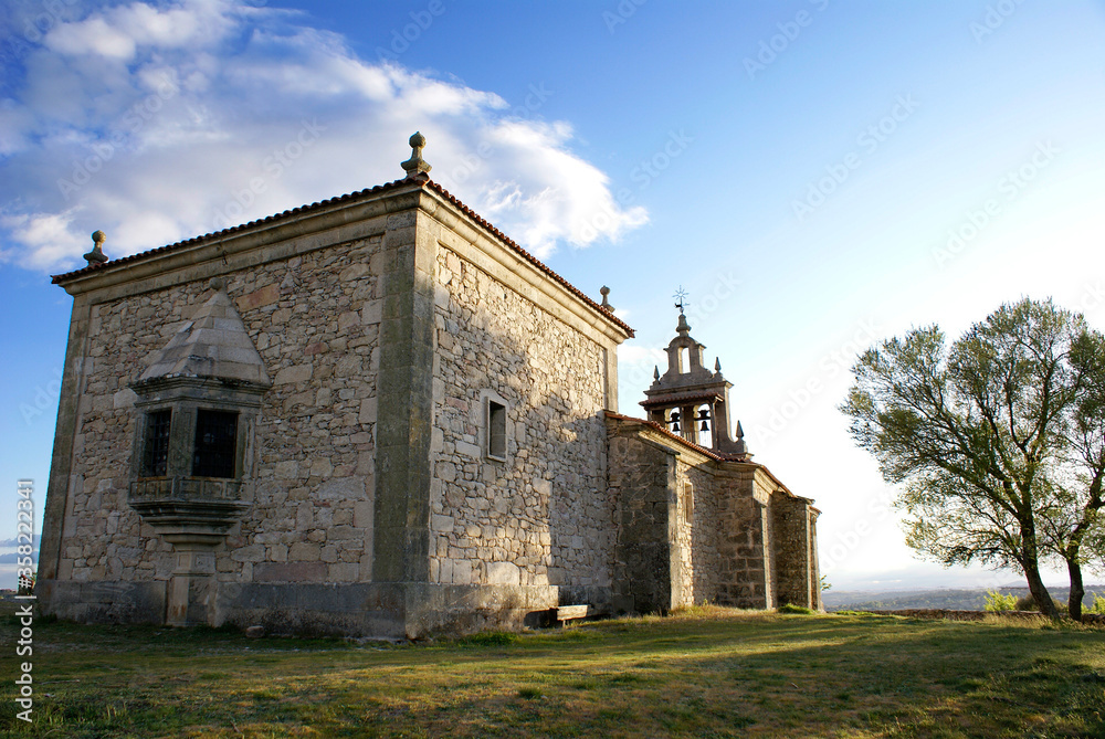 Isolated medieval Spanish Chapel with tree on the side in the north of Spain.