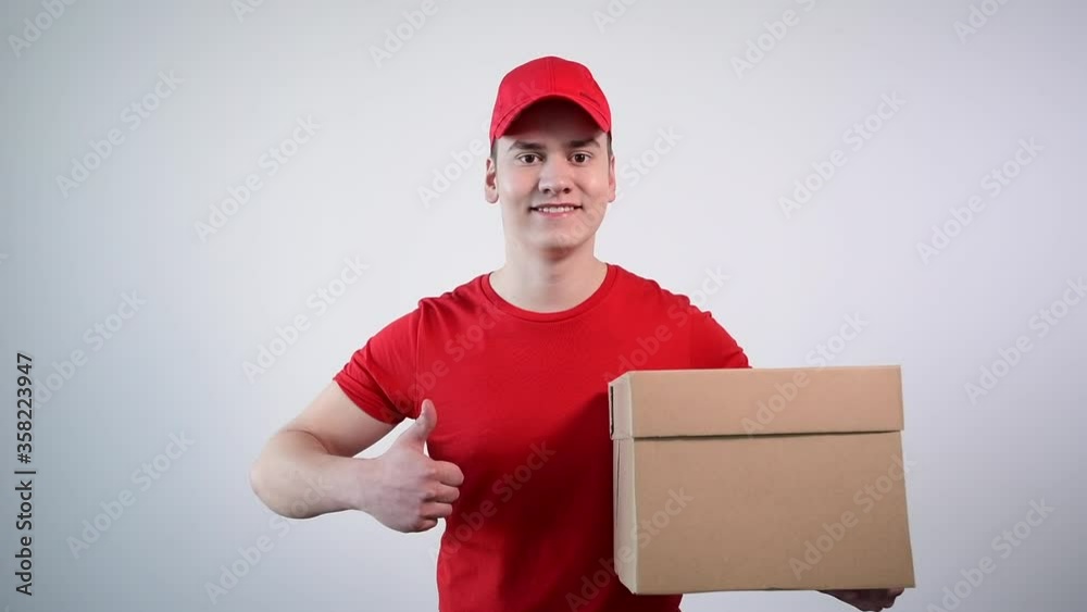 Close-up of a guy with a parcel in his hands showing a thumbs up gesture. Close-up of a guy with a parcel in his hands showing a thumbs up gesture.