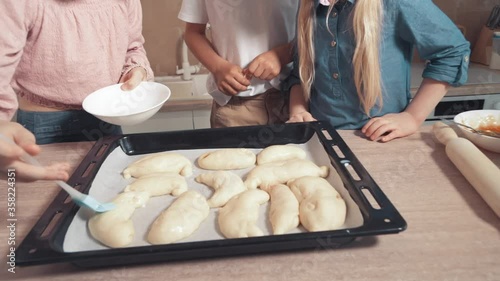 Children cook pastries and smear the dough with a silicone brush.