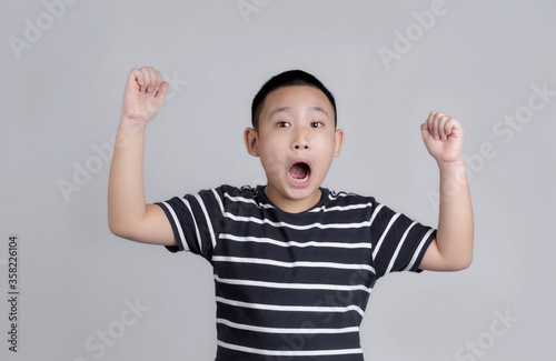 Asian boys studio portrait on gray background with looks shocked