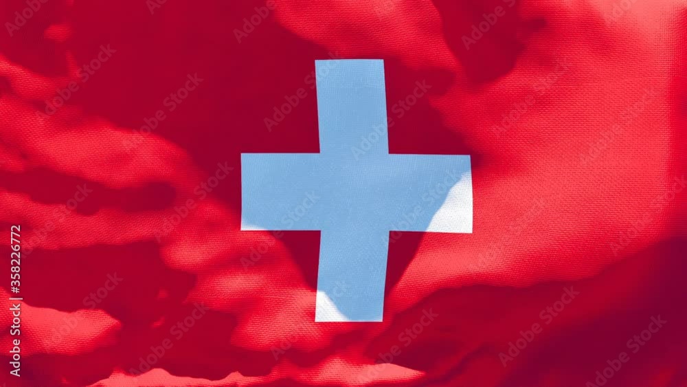 The national flag of Switzerland flutters in the wind The national flag of Switzerland flutters in the wind