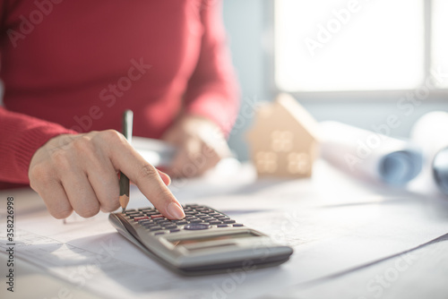 Architect working on blueprint. Architects workplace - architectural project, blueprints, ruler, calculator, laptop and divider compass. Construction concept. Blue print is fake only for stock photo.