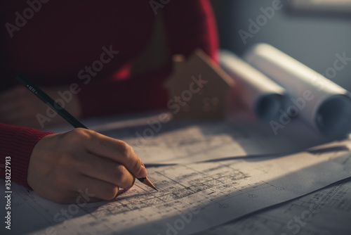 Architect working on blueprint. Architects workplace - architectural project, blueprints, ruler, calculator, laptop and divider compass. Construction concept. Blue print is fake only for stock photo.