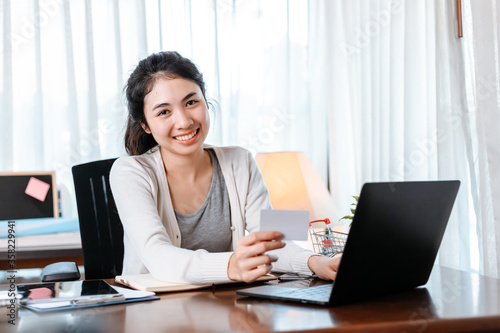 young woman hands holding credit card and using laptop for online shopping. Credit card buy or paymaent conceptl.