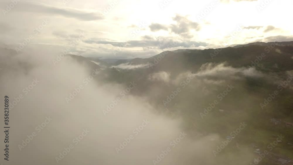 Aerial view flying thru the morning rain cloud covered tropical rain forest mountain landscape during the rainy season on the Doi Phuka Mountain reserved national park the northern Thailand Aerial view flying thru the morning rain cloud covered tropical rain forest mountain landscape during the rainy season on the Doi Phuka Mountain reserved national park the northern Thailand