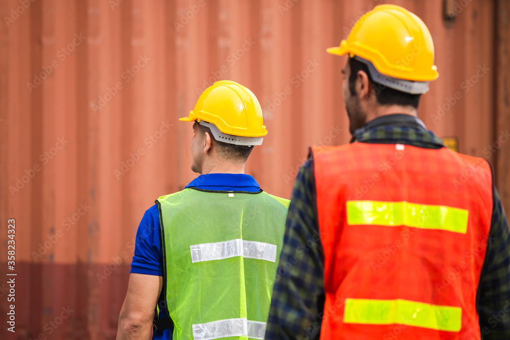 Rear view of Engineer and worker team in hard hat checking at containers cargo Rear view of Engineer and worker team in hard hat checking at containers cargo