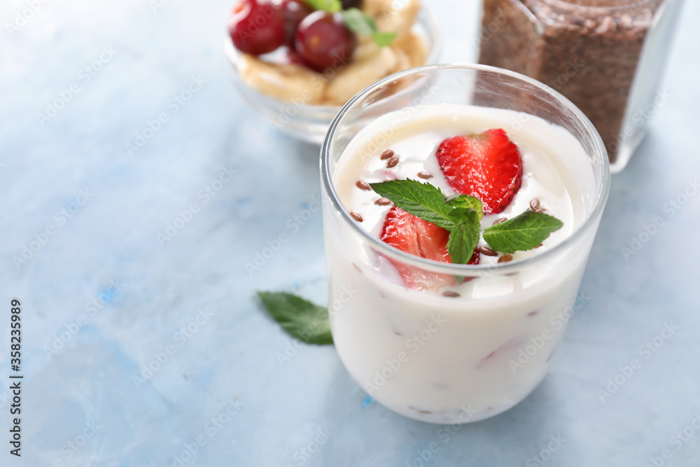 Glass of yogurt with strawberry and flax seeds on color background Glass of yogurt with strawberry and flax seeds on color background