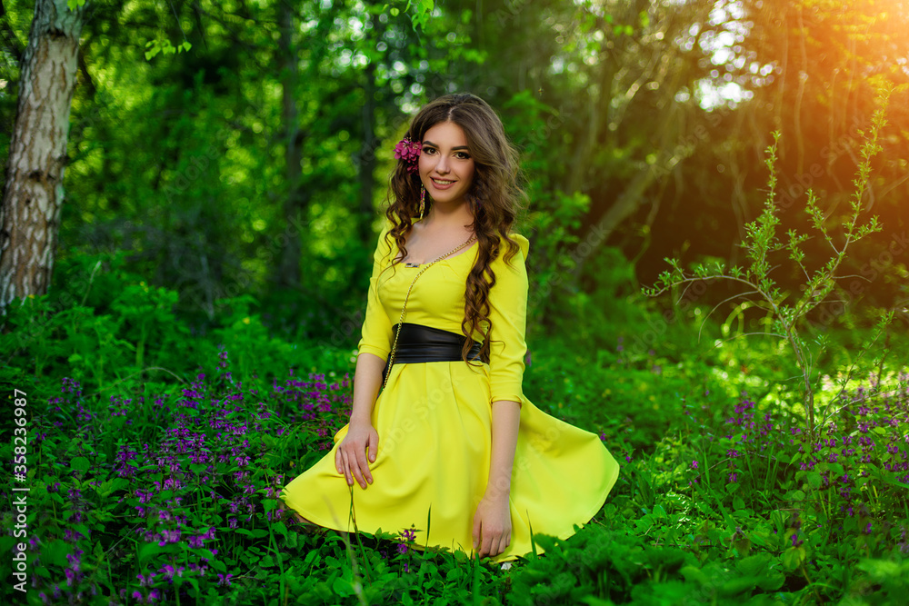 Young girl in yellow dress sitting on the ground with sunset light. Spring outdoors portrait Young girl in yellow dress sitting on the ground with sunset light. Spring outdoors portrait