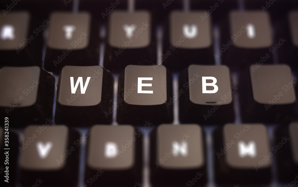 World Wide Web concept. Web text written on keypad. Black keys with white letters message of internet servers on pc keyboard. Blur buttons background. World Wide Web concept. Web text written on keypad. Black keys with white letters message of internet servers on pc keyboard. Blur buttons background.