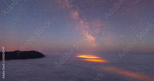 Lockdown time lapse shot of clouds by mountains against stars at night - Tofino, Canada photo